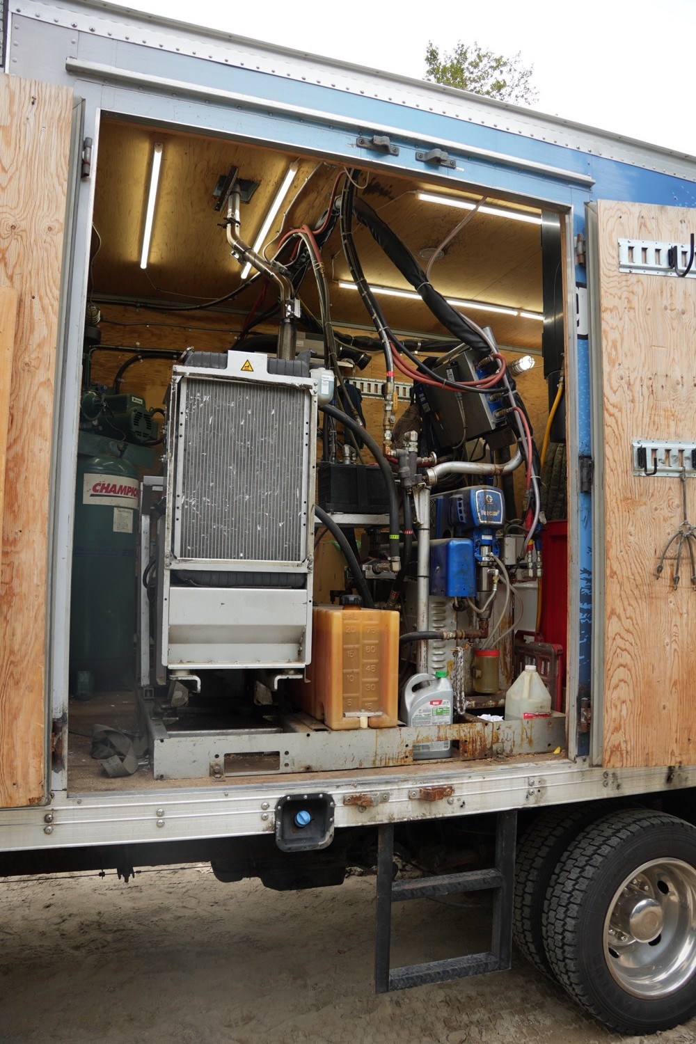 Spray foam proportioner and hose reels inside the truck